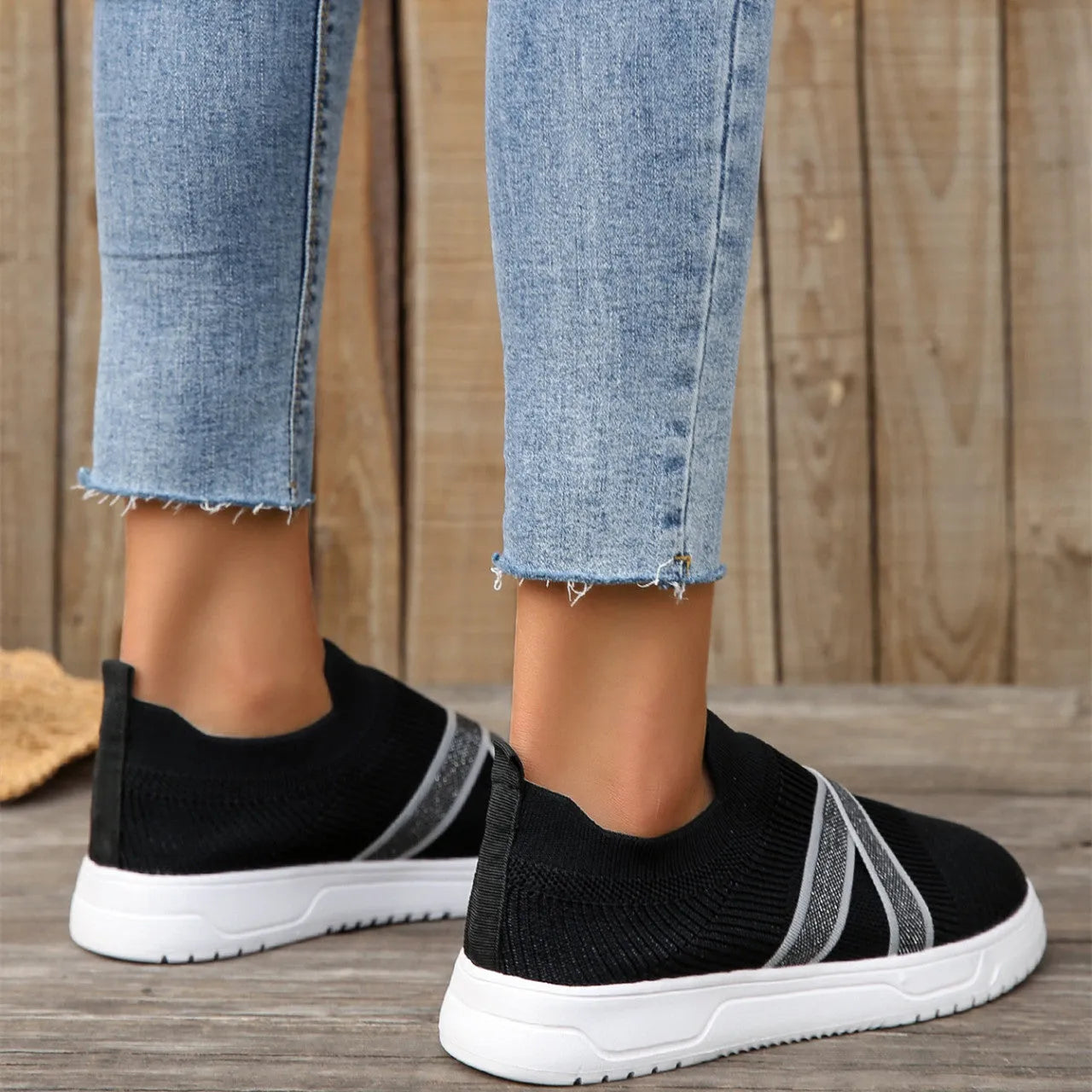 Black women's Flyknit mesh flat shoes with a tassel detail on the low-top upper and a flat rubber sole.