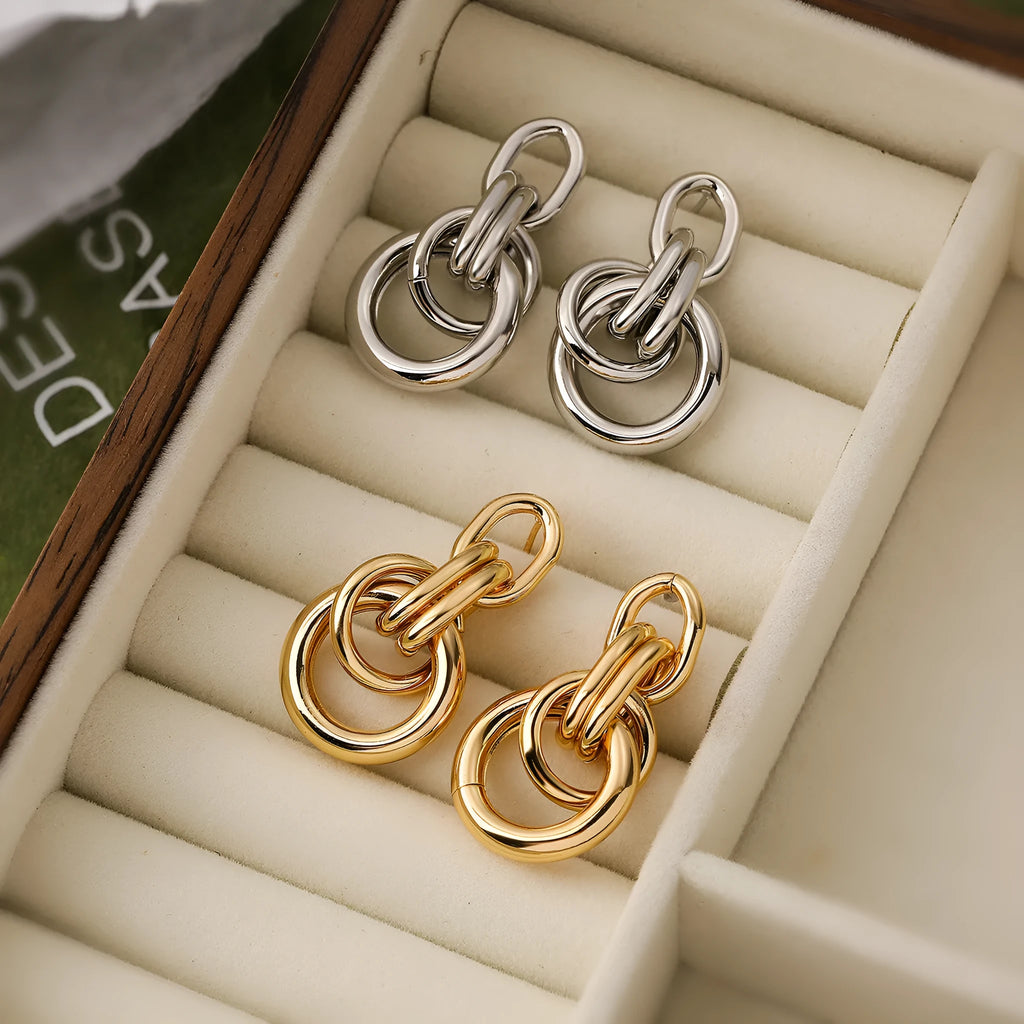 Geometric gold-colour drop earrings with irregular details and high-profile construction