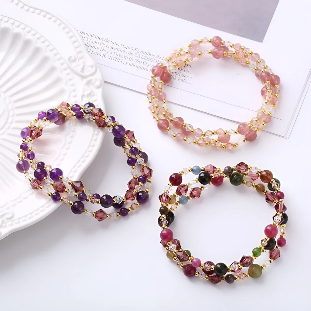 Women's three-ring bracelet with tourmaline, strawberry quartz, and amethyst crystals on an adjustable rope.