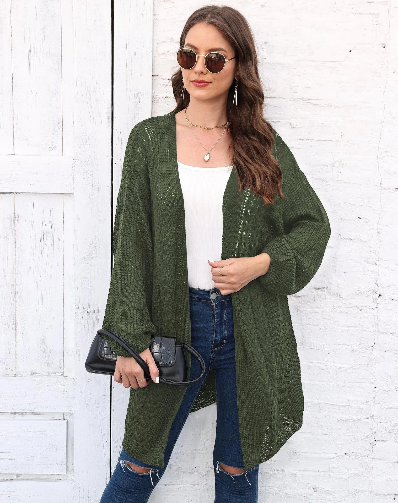 A woman's loose-fitting, solid-colour acrylic sweater coat on a hanger.