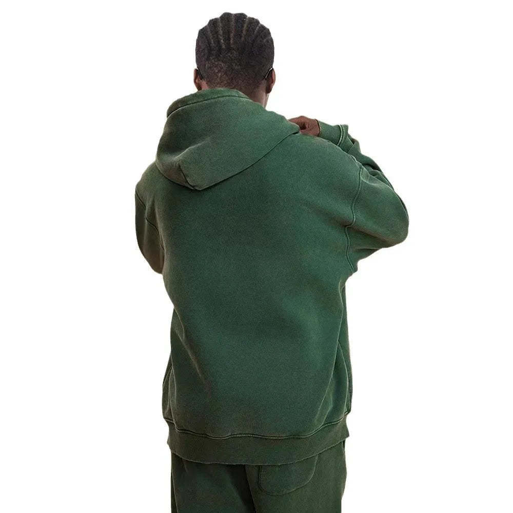 Man wearing a vintage wash fleece-lined hooded cardigan with a double zipper, shown in dark green.