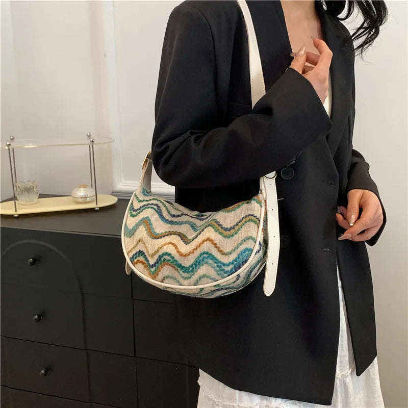 Women's straw woven crossbody bag showing texture and internal phone and file compartments.
