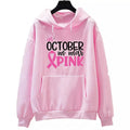 Women's pink pullover hoodie with 'In October We Wear Pink' and 'I'm A Survivor' retro hot stamping design and side seam pockets.