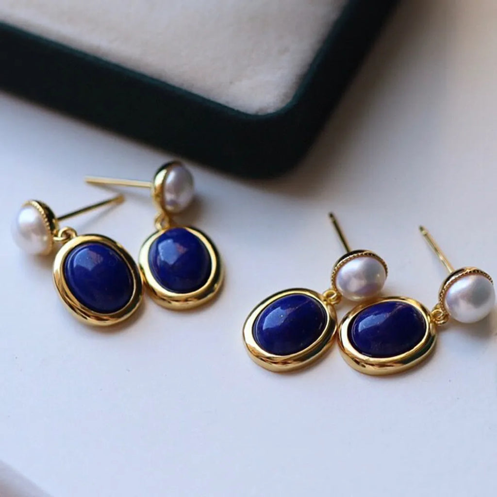 A pair of simple sterling silver earrings featuring a blue lapis lazuli pearl and auspicious patterns.