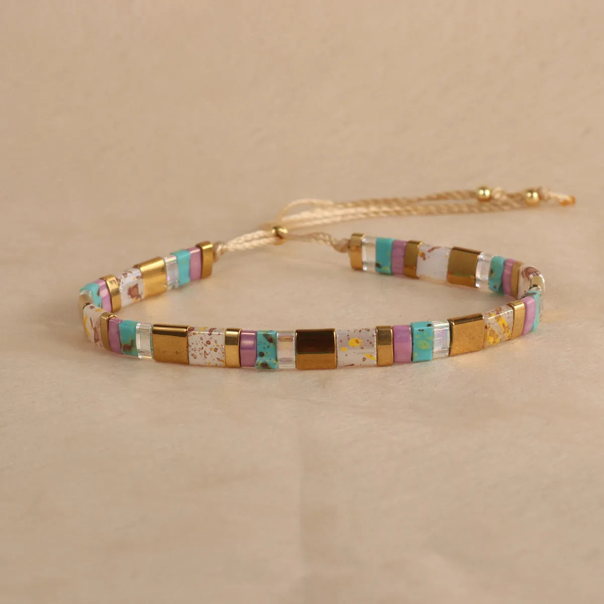 Adjustable glass beaded bracelet in geometric design with round beads available in five colours