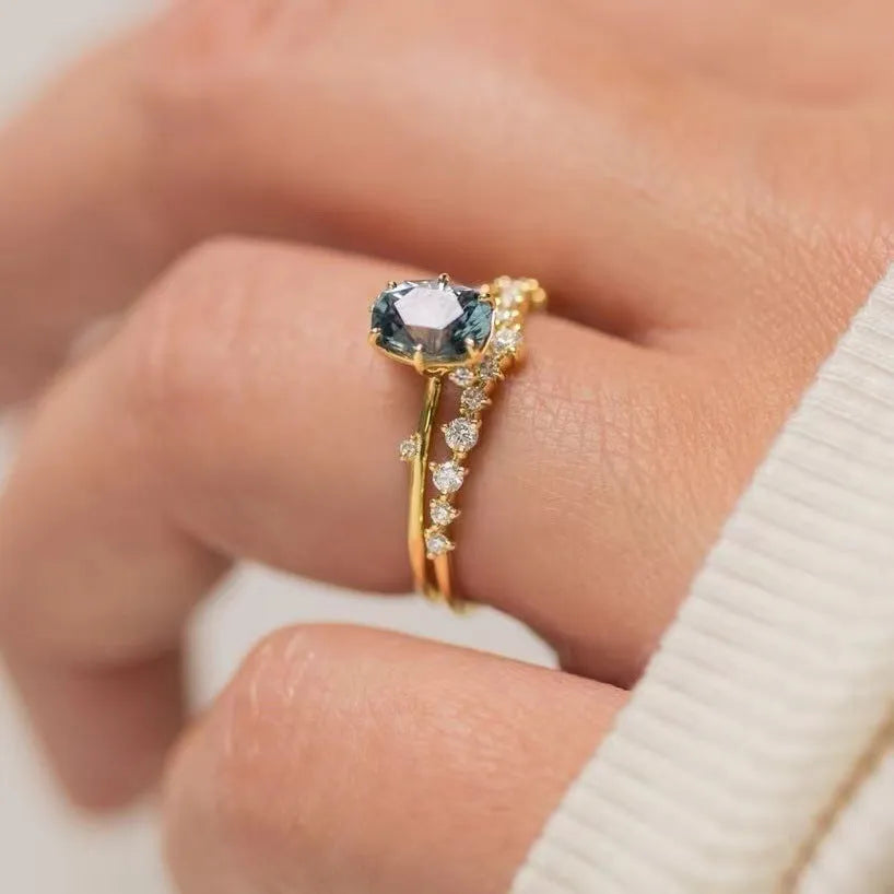Gold plated flower-shaped ring with inlaid green zircon stones on a white background.