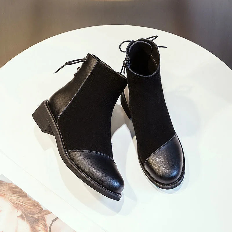 Women's black knee-high Martin boots with side zipper, round toe, and short stout heel.