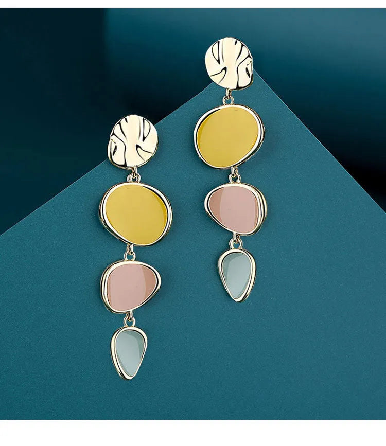 A pair of simple disc-shaped alloy earrings with a blended Morandi three-colour oil drip finish, showing a vintage wafer style.