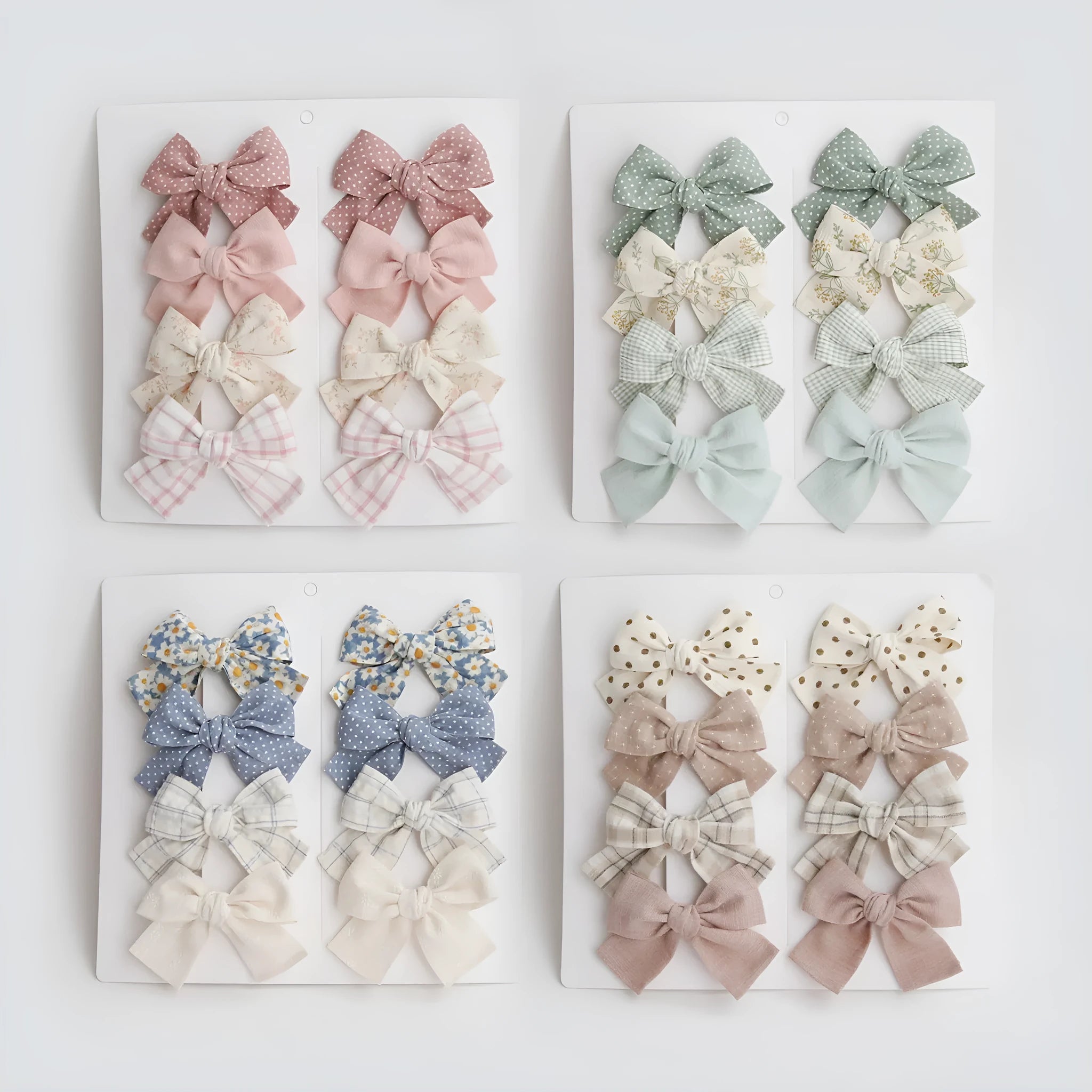 Set of eight children's cloth bow hairclips in assorted colours including beige, blue flowers, and polka dots.