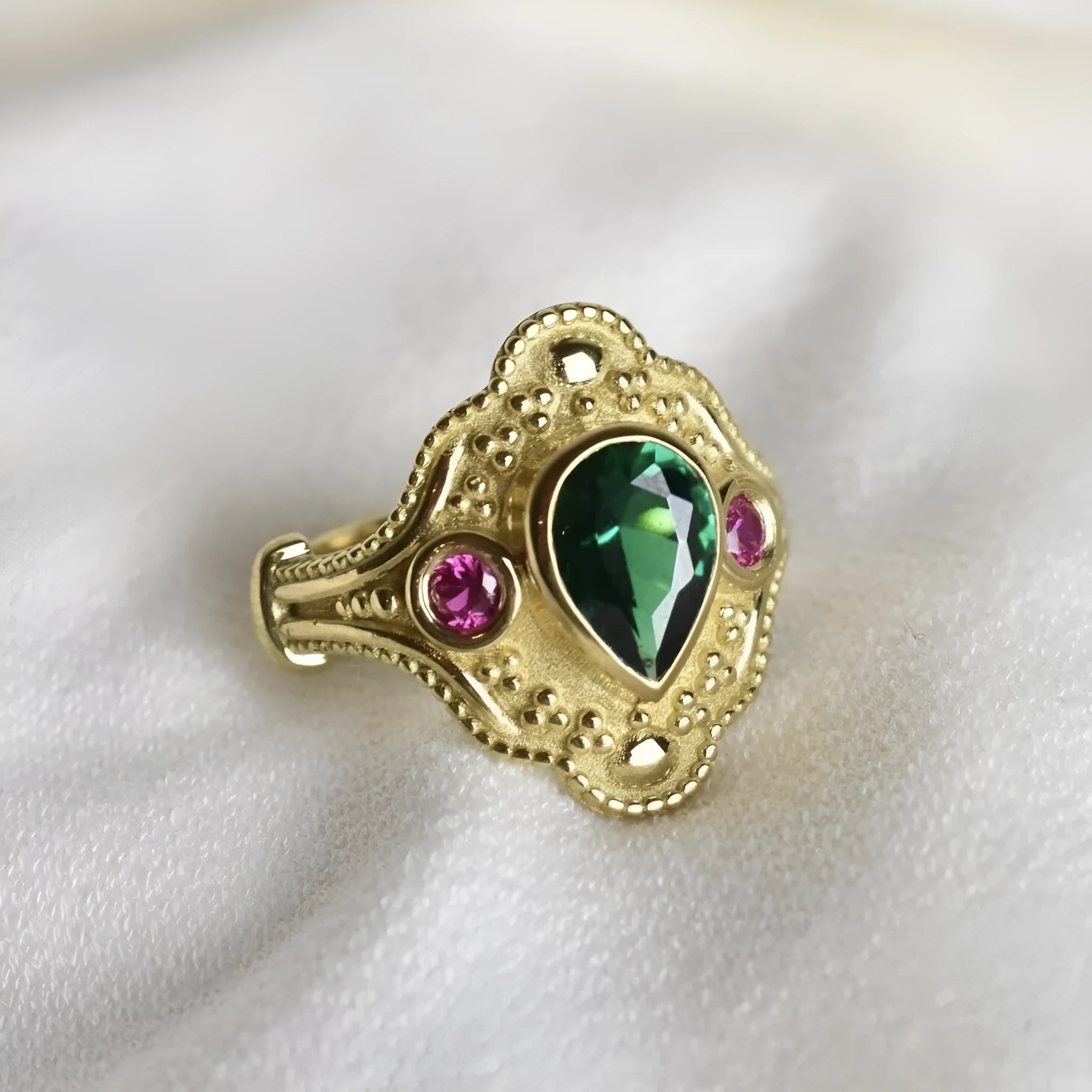 Golden geometric women's ring on a plain background, showing its alloy construction and electroplated finish.