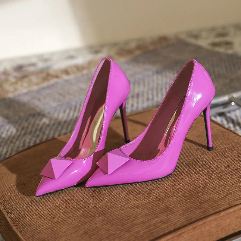 Pink pointed toe stiletto high heels with a buckle detail on the patent leather upper.