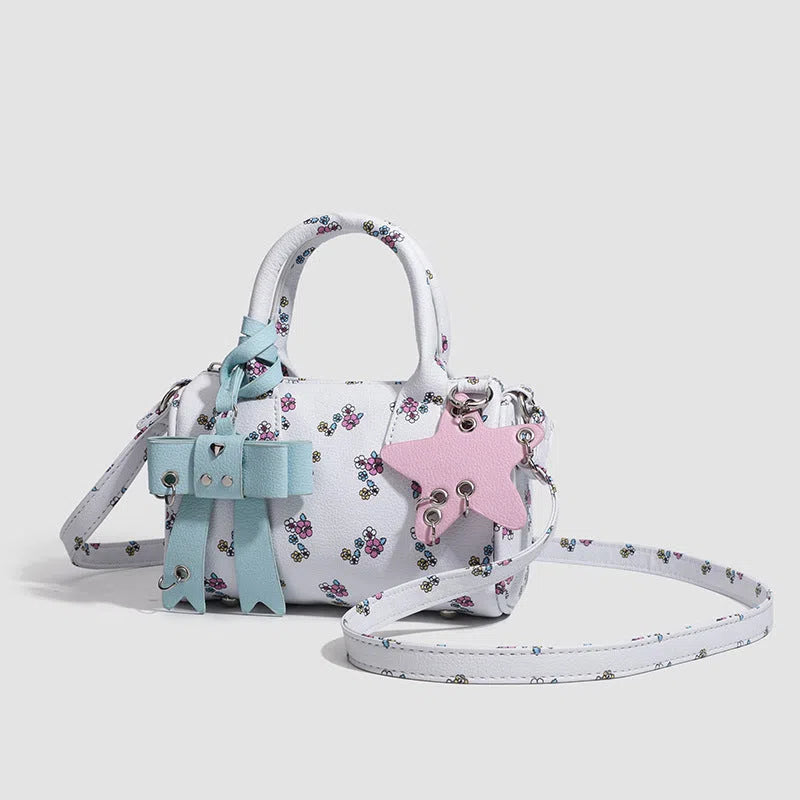 White PU hand-held shoulder bag with petite floral bow accessory on display