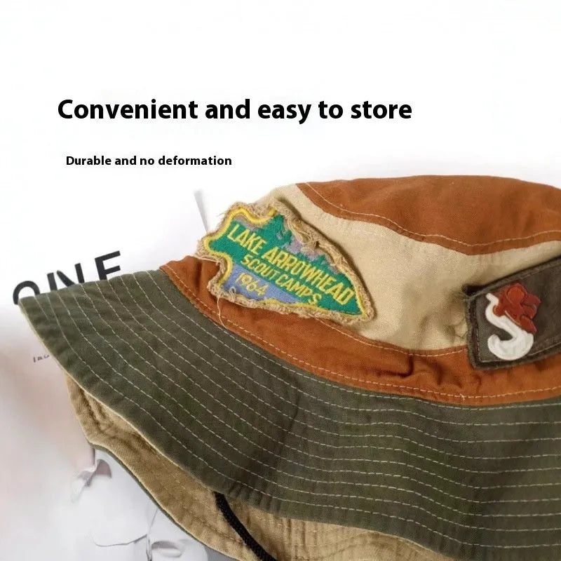 Army green cotton fisherman hat with patchwork design and flat top crown, shown folded for storage