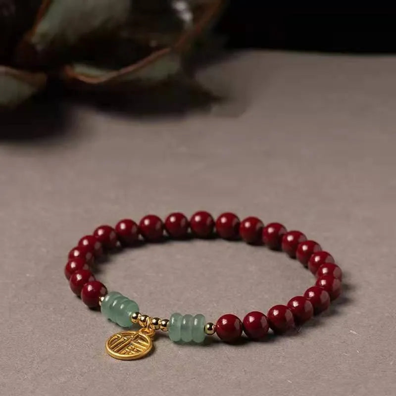 Handmade wave-shaped bracelet in cinnabar and copper beads on a wrist.