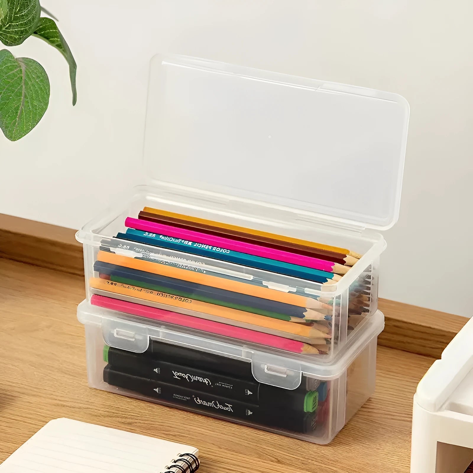 Transparent plastic stationery storage box with pencils and crayons inside