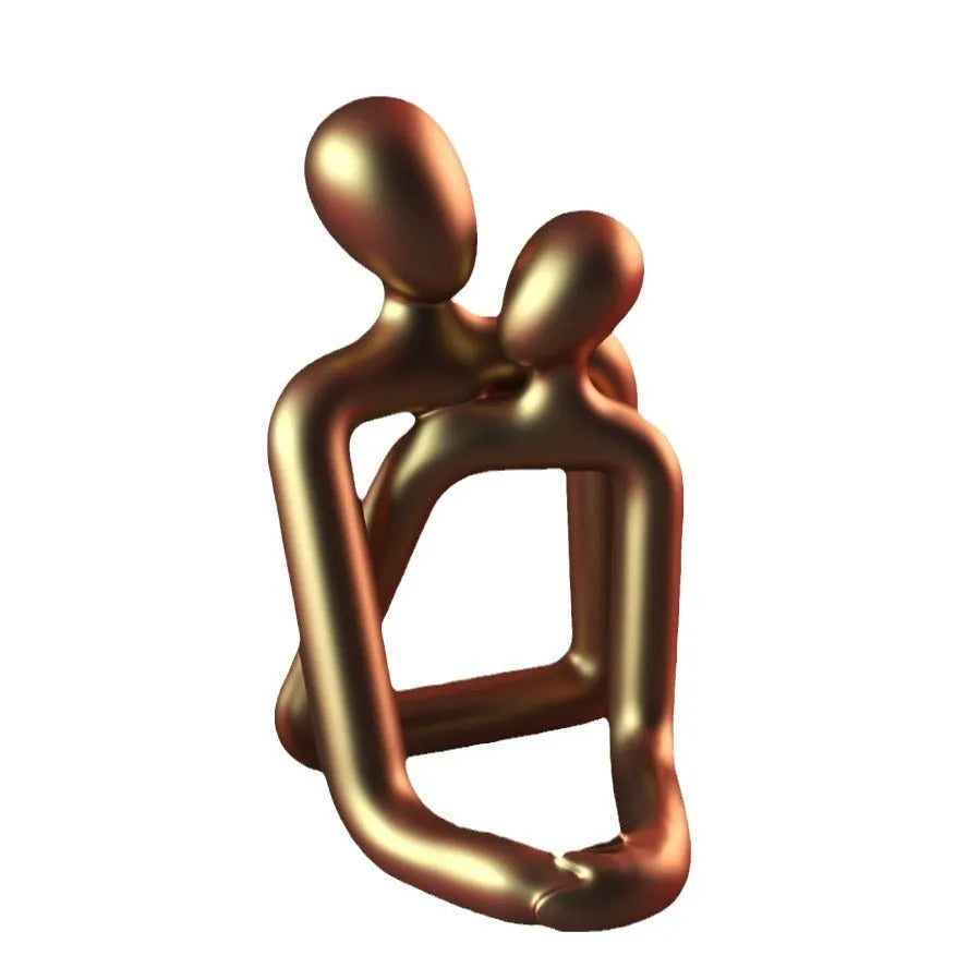 Modern minimalist loving couple resin statue in milky white or gold finish on a desk.