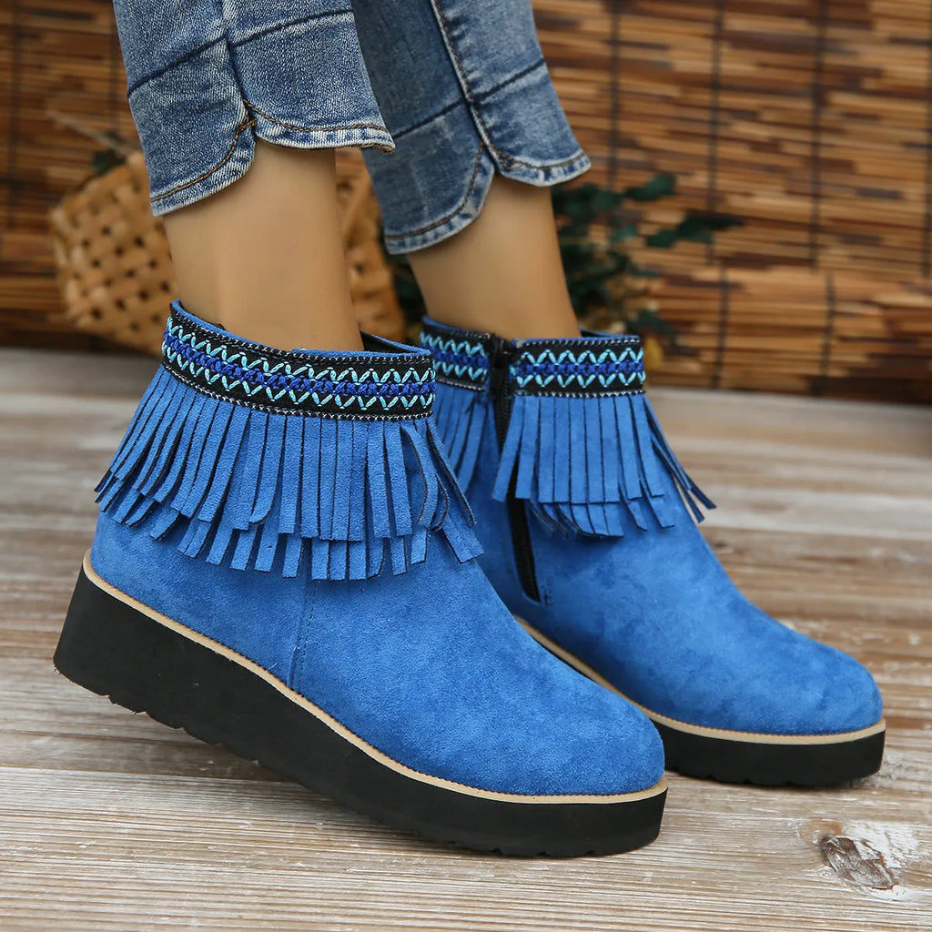 Women's dark brown suede wedge ankle boot with side zipper and tassel detail on a thick rubber sole.