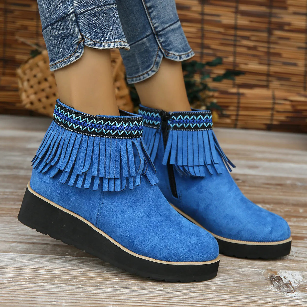 Women's dark brown suede wedge ankle boot with side zipper and tassel detail on a thick rubber sole.