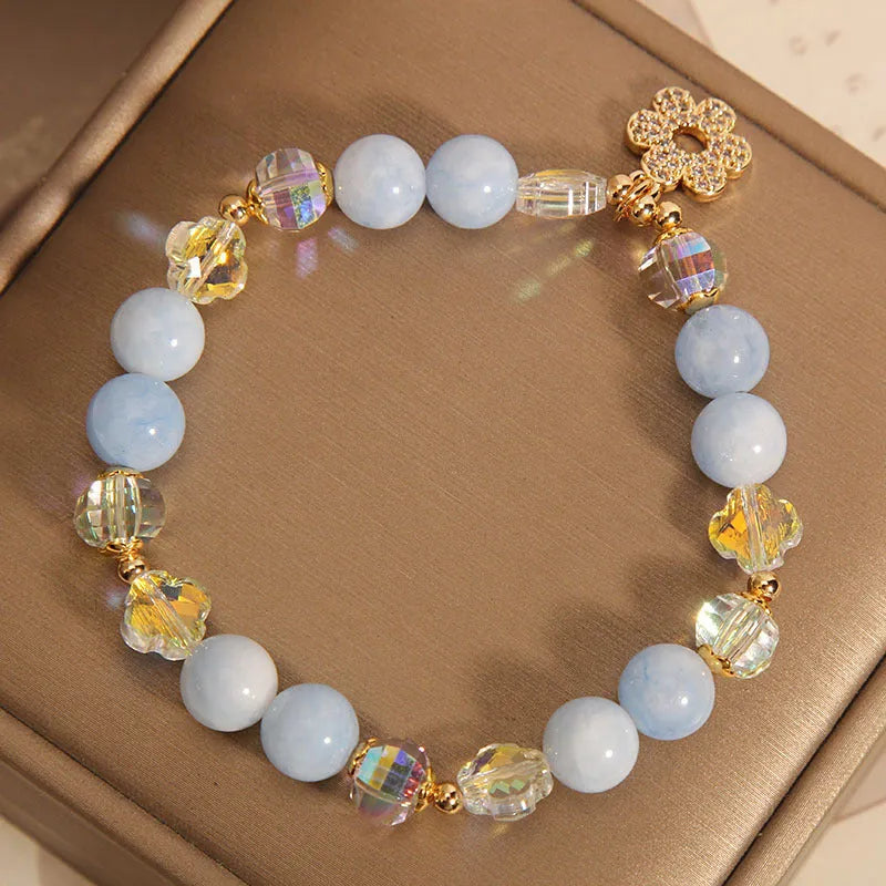 Women's aquamarine crystal bracelet with a four-leaf clover charm and pearl decorative accents