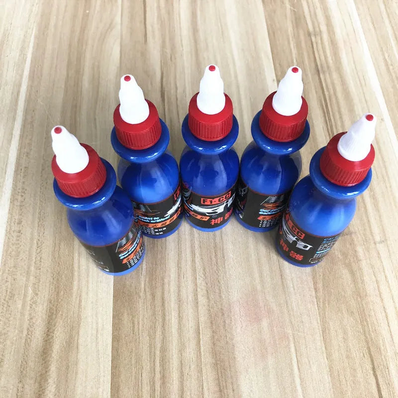 Small blue car wiping tool and bottle of scratch repair agent for DIY automotive scratch removal.