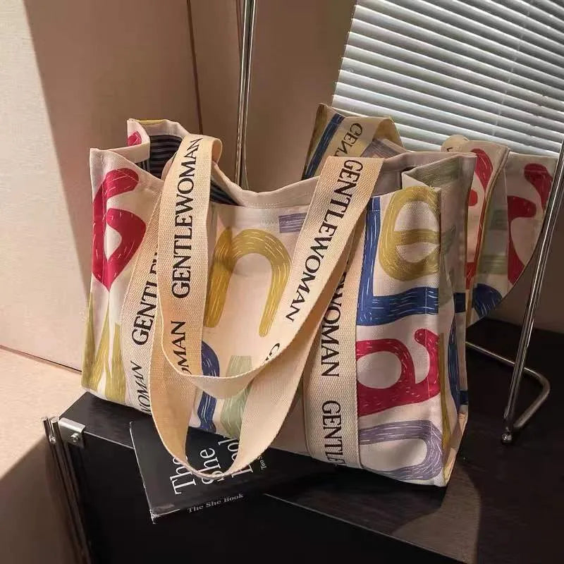 Canvas tote bag with printed design options including black letters, coloured letters, and pattern styles