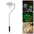 White solar-powered diamond-shaped garden spotlight with adjustable head on a stake for outdoor installation.