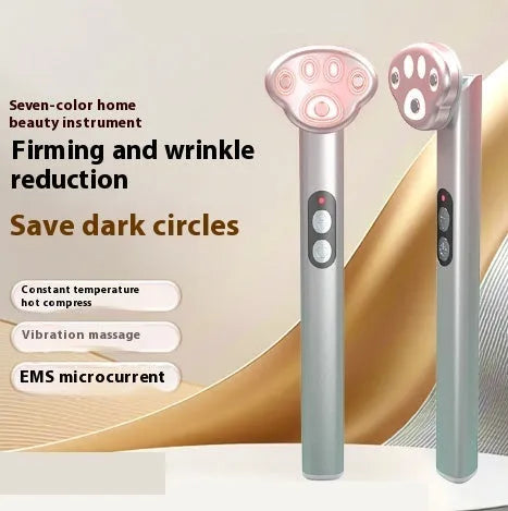 Gradient pink cats paw shaped micro-current eye massager on a white background