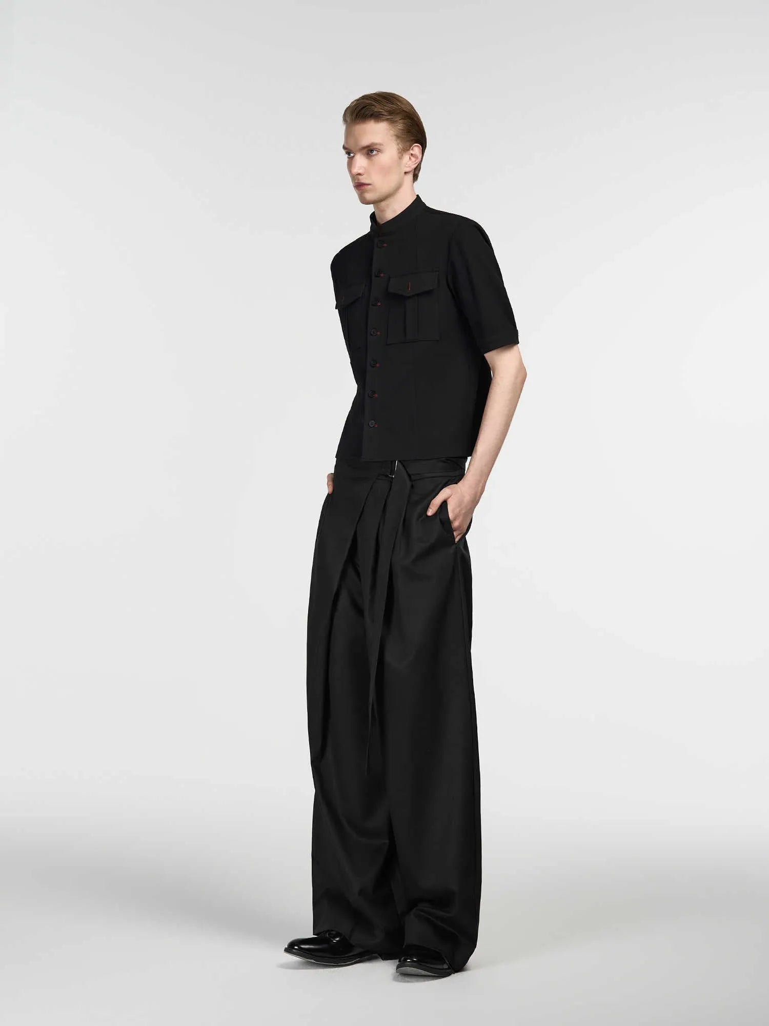 Black straight-leg trousers with a single pleat and adjustable waistband on a plain background.