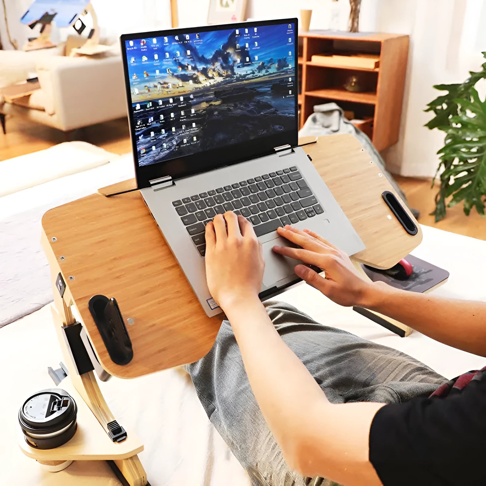 White maple wooden folding laptop table on a bed, set at an adjustable angle.