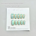 Set of electroplated Cat's Eye false nails with Aurora shine in short ladder sizes on a plain background.