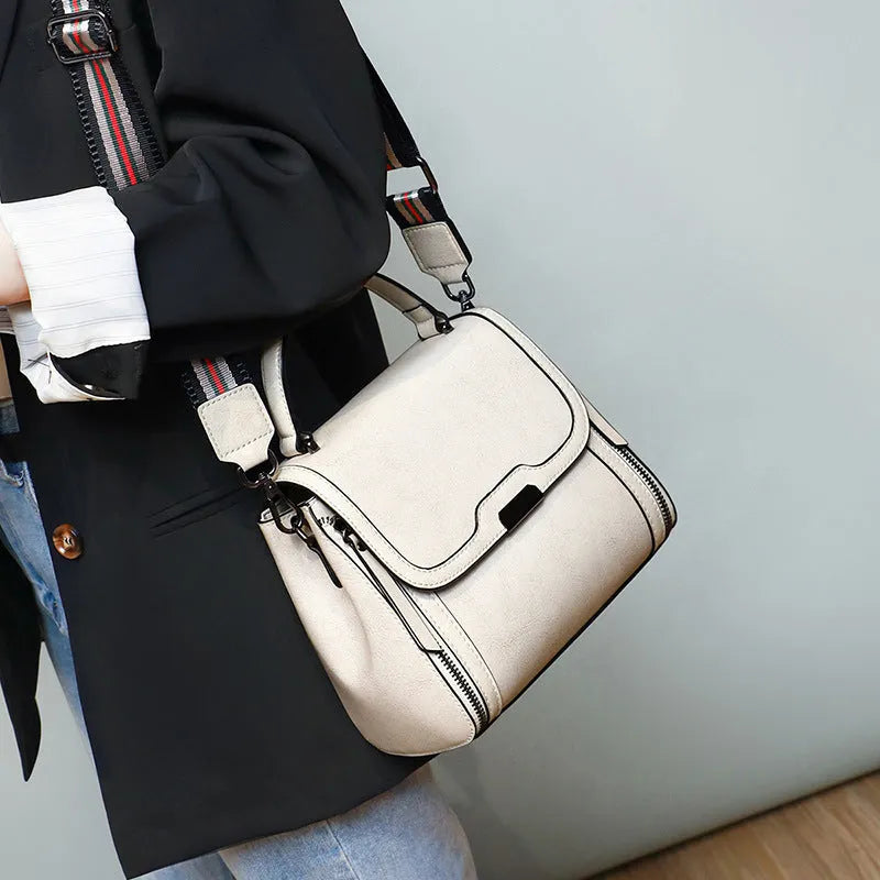 Genuine leather women's retro messenger bag in brown, showing internal organiser pockets and shoulder strap.