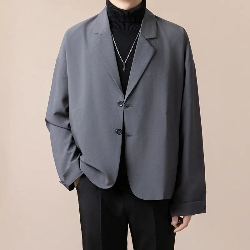 Man wearing a loose fit casual suit jacket in apricot colour, suitable for light business settings.