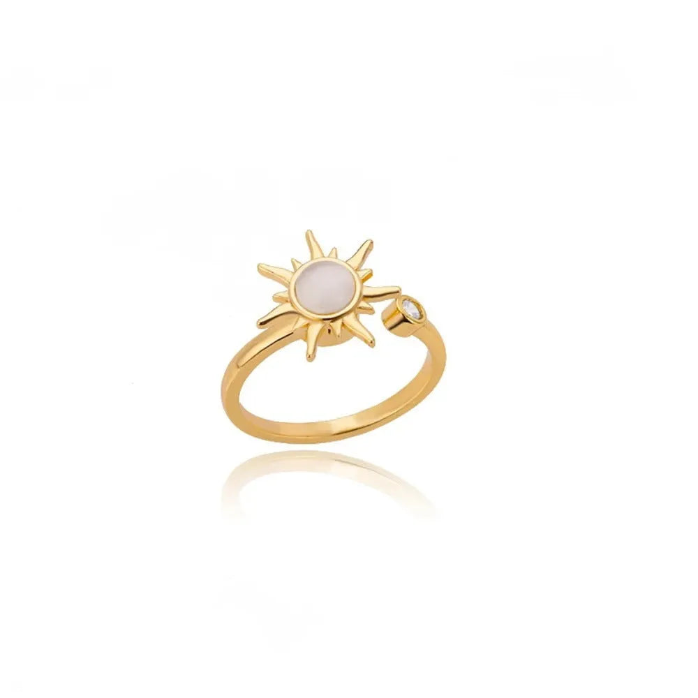 Gold and platinum coloured adjustable geometric decompression ring with rotatable element on a white background.