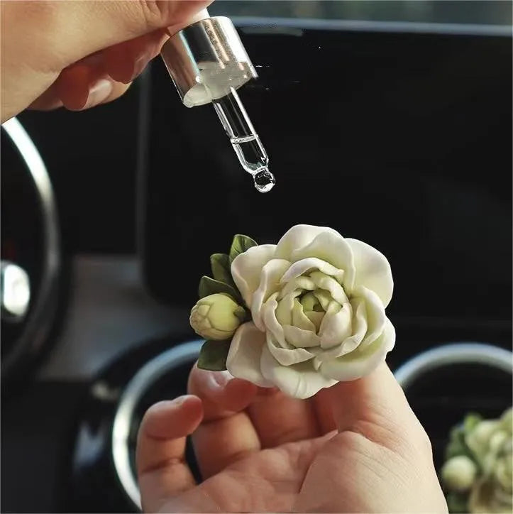 Jasmine solid car perfume gypsum tablet clipped to a car air vent.