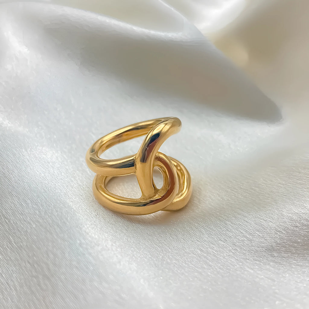 Women's stainless steel geometric ring with a knotted detail and adjustable opening in gold or steel colour.