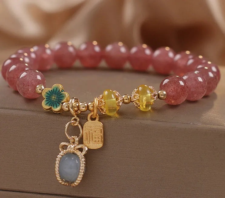 Red women's bracelet with natural strawberry quartz beads, alloy metal chain, and rhinestone details.