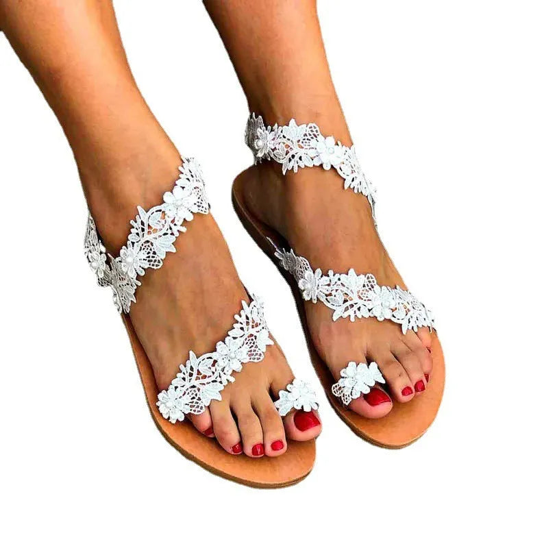 White women's flat sandals with rhinestone flower decoration on the upper.