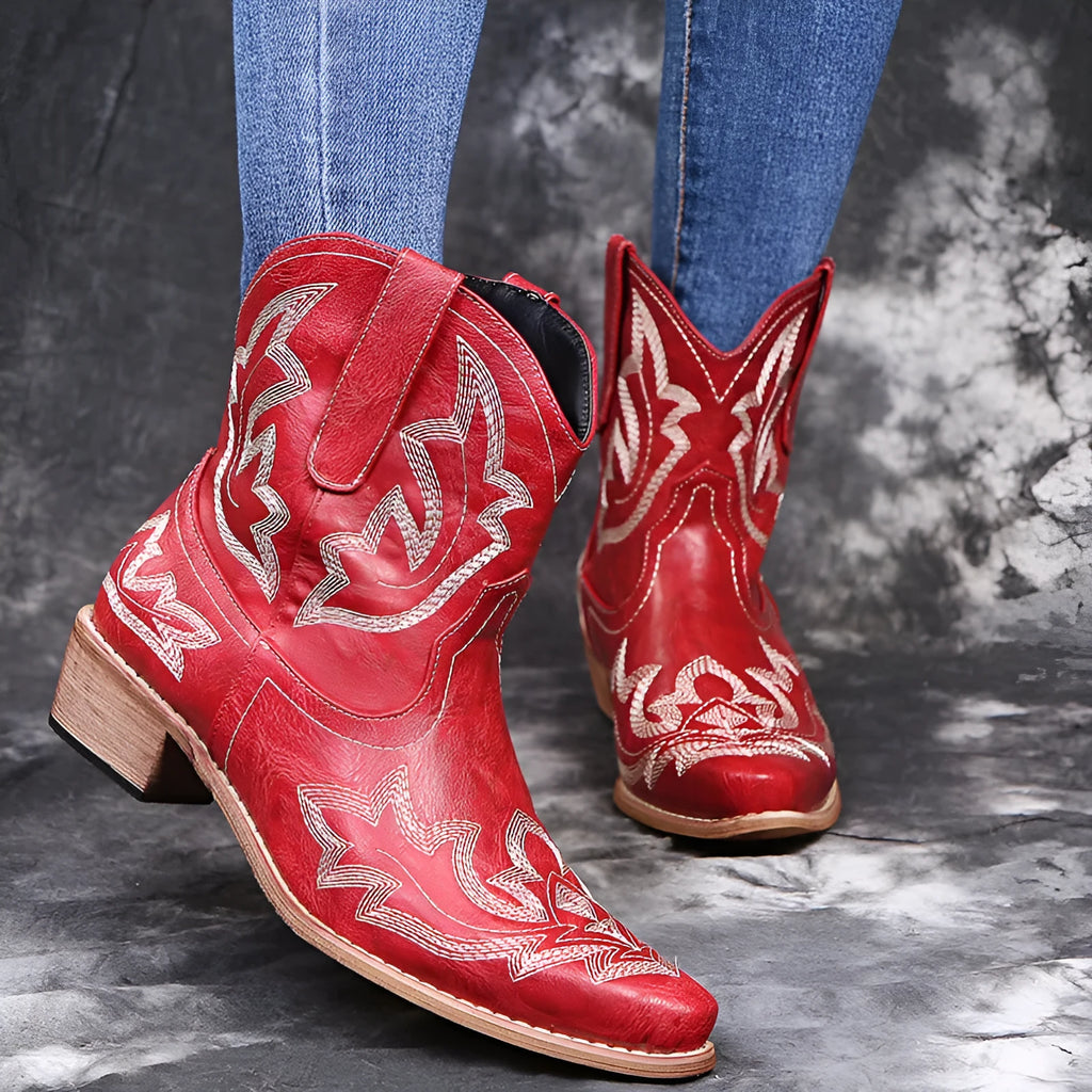 Women's blue cowboy boots with wedge heel, pointed toe, and embroidery details on low canister.