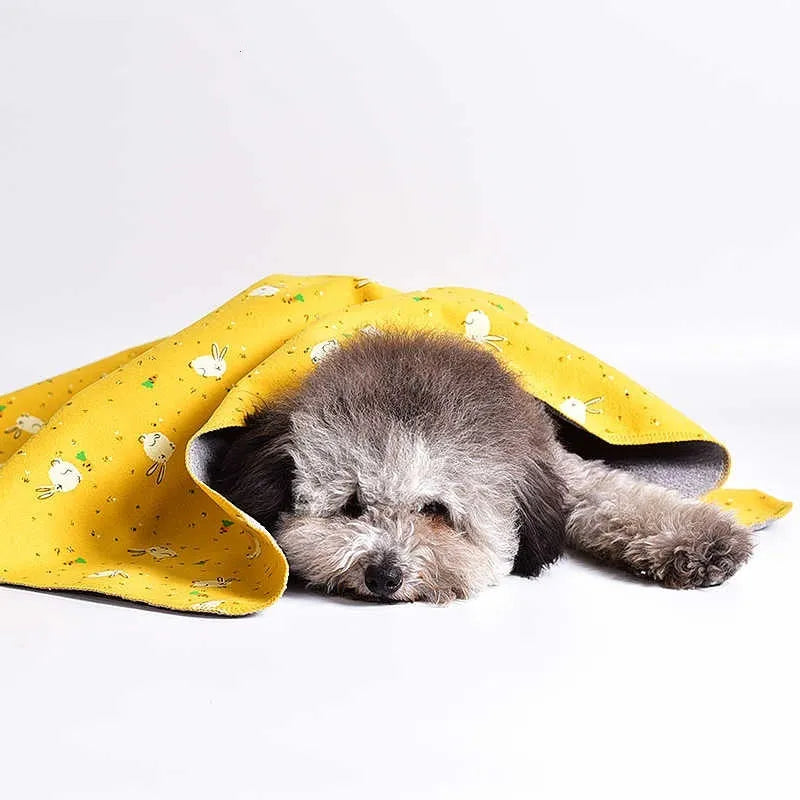 Colourful double-sided cotton wool pet blanket with dinosaur and cartoon bear prints laid flat.