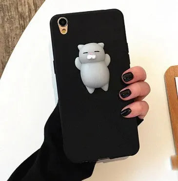 Soft silicone iPhone case with a raised 3D cartoon cat design, shown in pink.