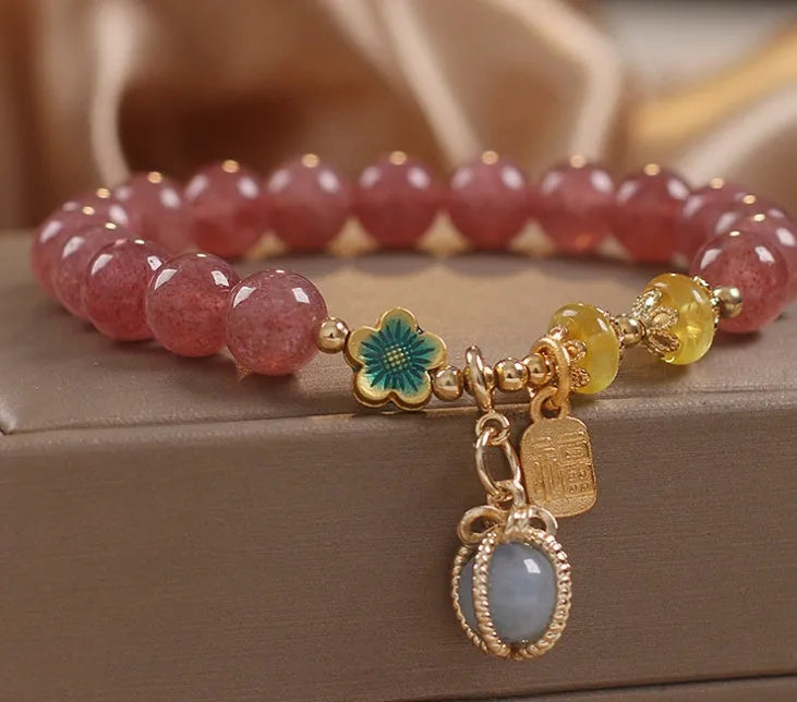 Red women's bracelet with natural strawberry quartz beads, alloy metal chain, and rhinestone details.