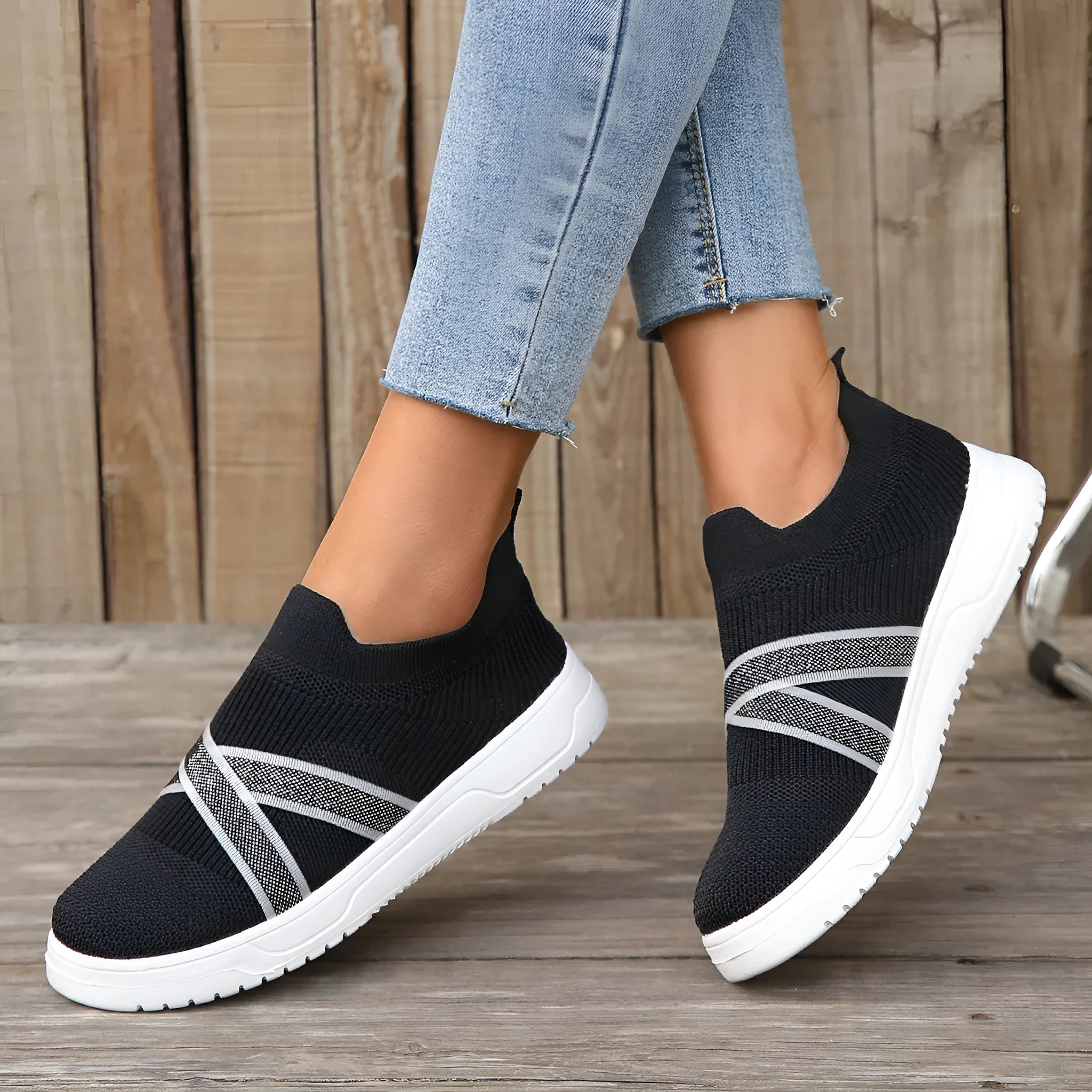 Black women's Flyknit mesh flat shoes with a tassel detail on the low-top upper and a flat rubber sole.