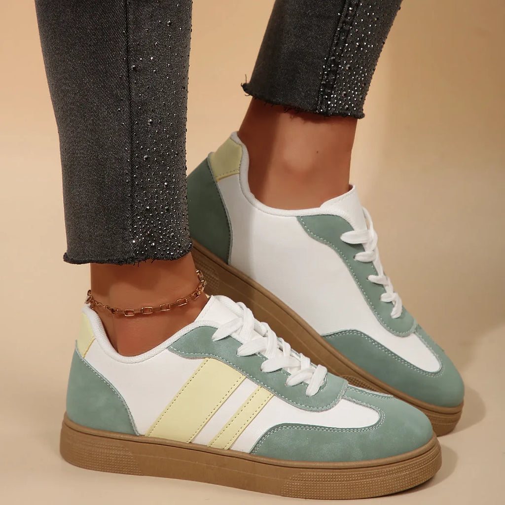 Women's green retro sports shoes with white cross straps, low top, flat rubber sole, and round toe.