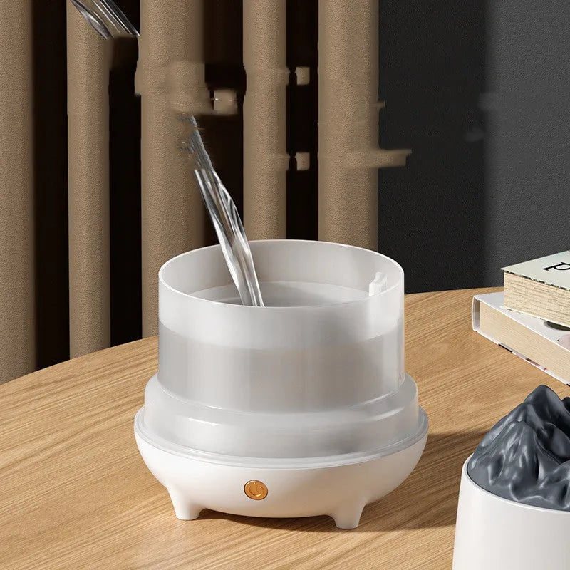 White volcano-shaped ultrasonic humidifier and aromatherapy diffuser on a table.