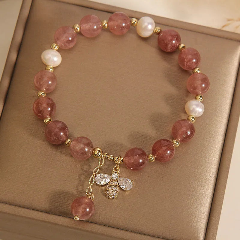 Women's freshwater pearl and strawberry quartz bracelet with zircon accents on wrist