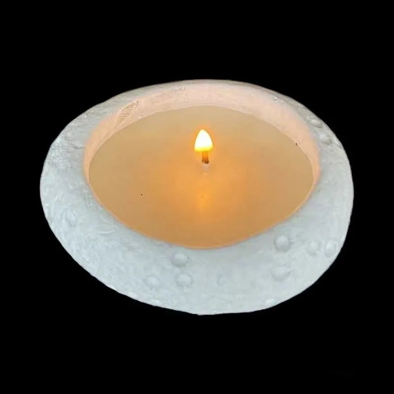 Fair-faced concrete candlestick ornament in white colour on a flat surface
