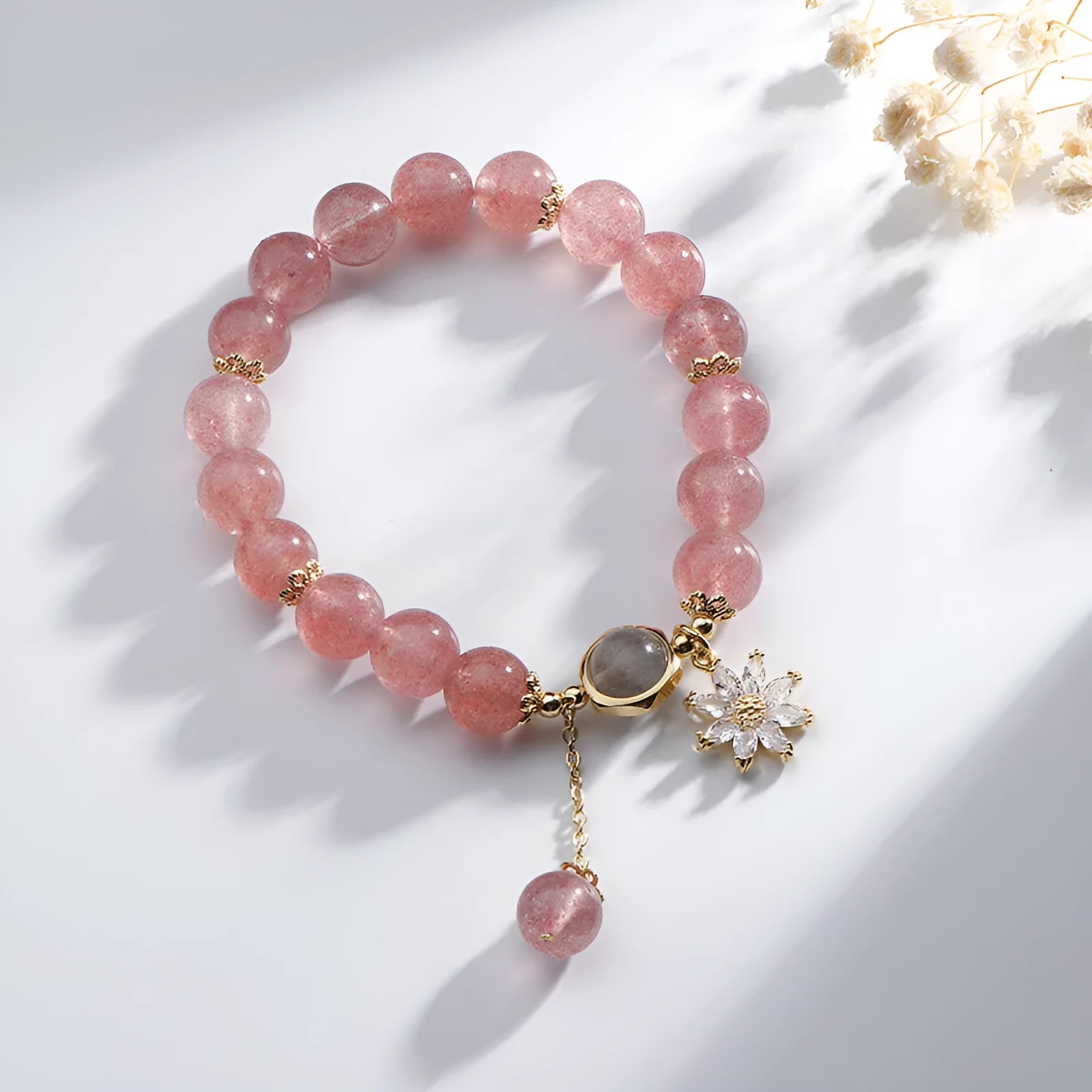Strawberry quartz Mori style bracelet with electroplated floral details on a white background