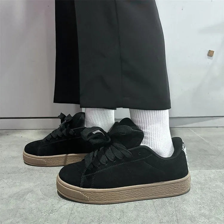 Black retro low-top sneakers for men and women on a white background, showing round toe and lace-up design.