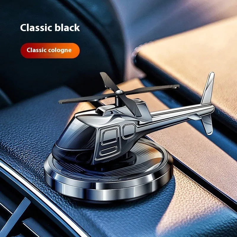 Silver metal solar helicopter car perfume ornament with rotating blades on car dashboard