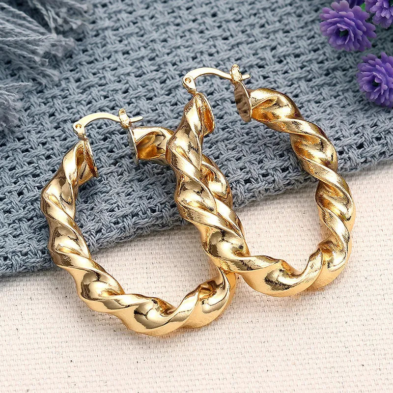 Close-up of women's geometric drop-shaped clip-on earrings with ring and line design in a copper and electroplated finish.